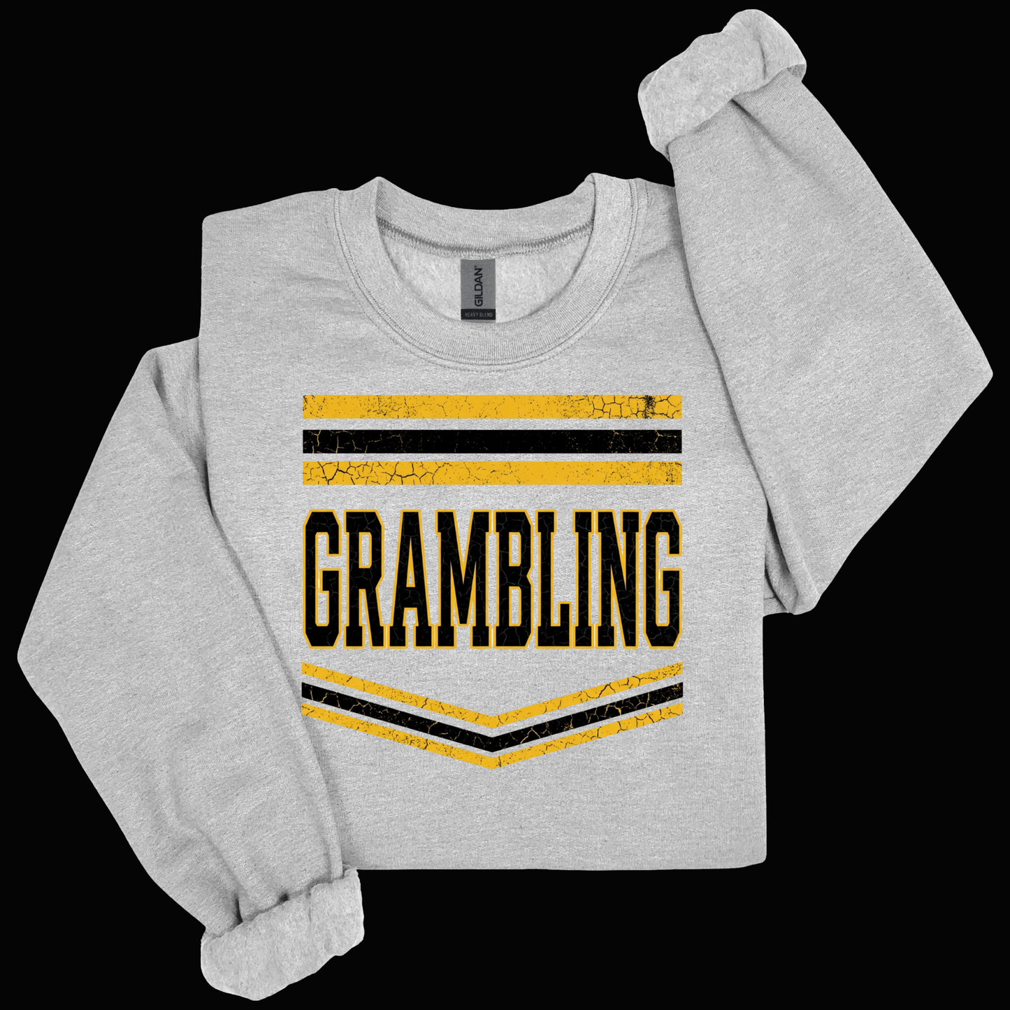 A light heather gray long-sleeve sweatshirt with rolled cuffs, featuring a distressed yellow and black graphic on the front that reads 'GRAMBLING' with horizontal stripes above and chevron stripes below, shown on a solid black background.