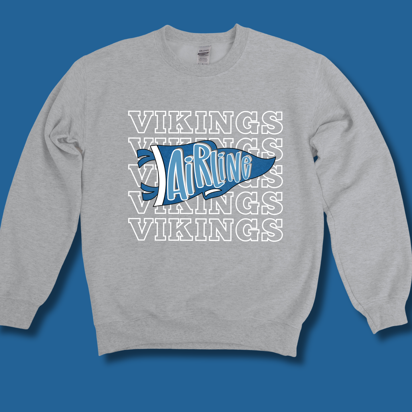 A heather gray crewneck sweatshirt featuring a blue and white graphic on the chest. The graphic displays a stylized blue pennant with the word 'Airline' in white script, layered over a repeating white outline pattern of the word 'VIKINGS'.
