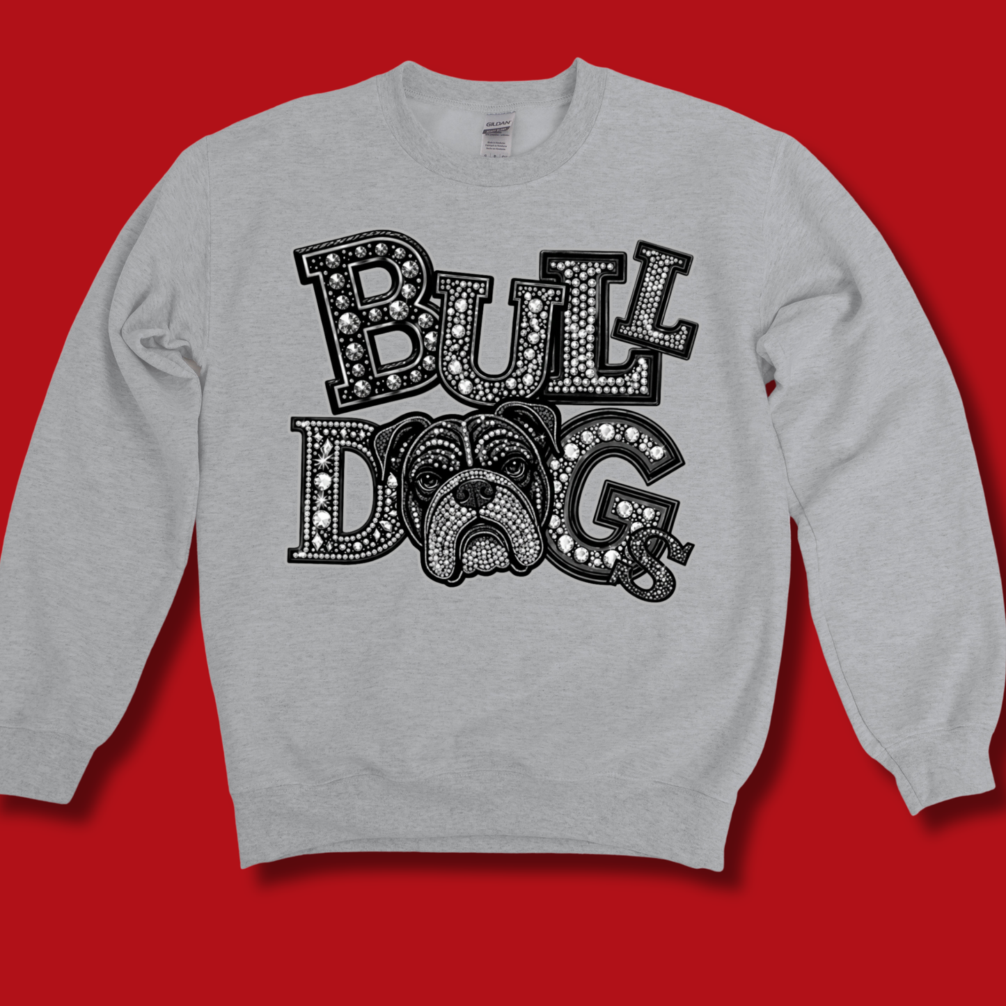 A light heather gray crewneck sweatshirt featuring a large black graphic print that reads 'BULLDOG' in decorative block letters, with a bulldog face integrated into the design, displayed against a solid red background.