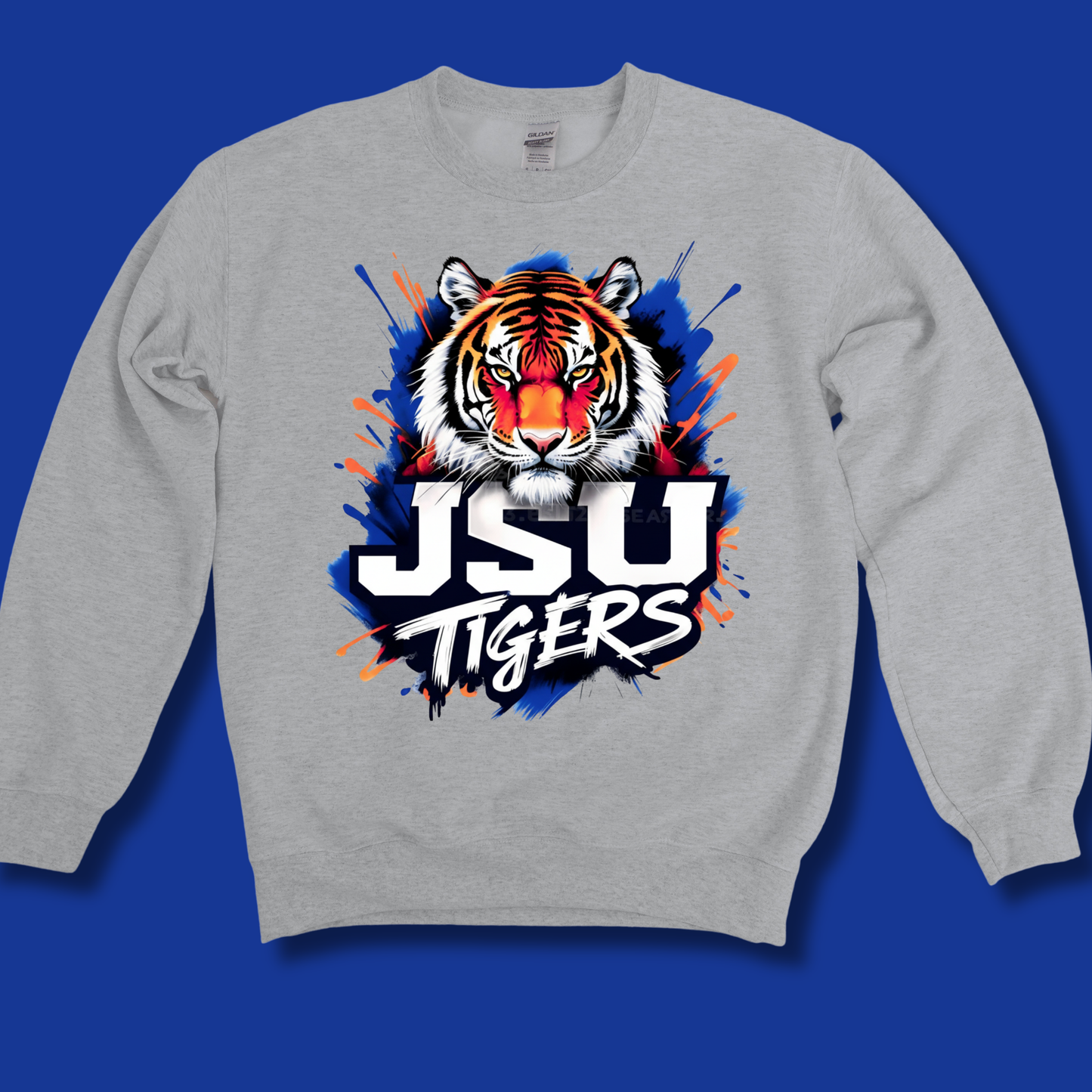 A light gray crewneck sweatshirt featuring a large graphic of a tiger's face and the text 'JSU TIGERS' in white, black, and orange, set against a solid blue background.