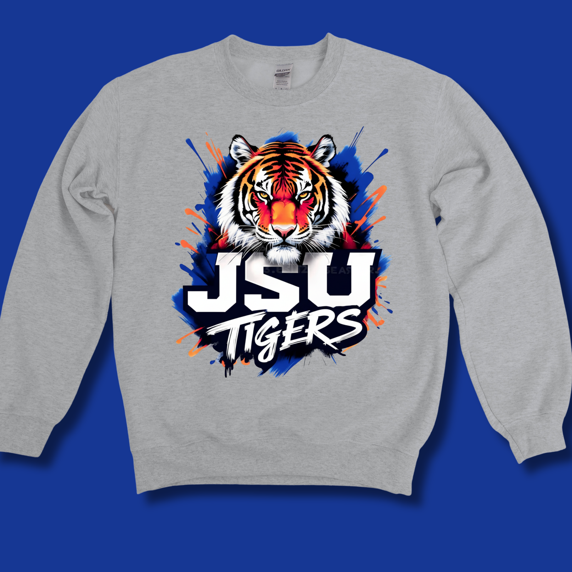 A light gray crewneck sweatshirt featuring a large graphic of a tiger's face and the text 'JSU TIGERS' in white, black, and orange, set against a solid blue background.
