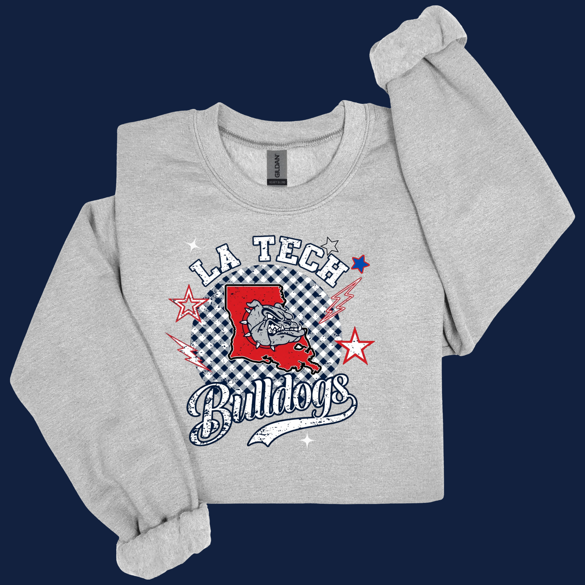 A light heather gray crewneck sweatshirt featuring a 'LA Tech Bulldogs' graphic on the front, styled with rolled cuffs and a folded sleeve against a dark navy blue background.