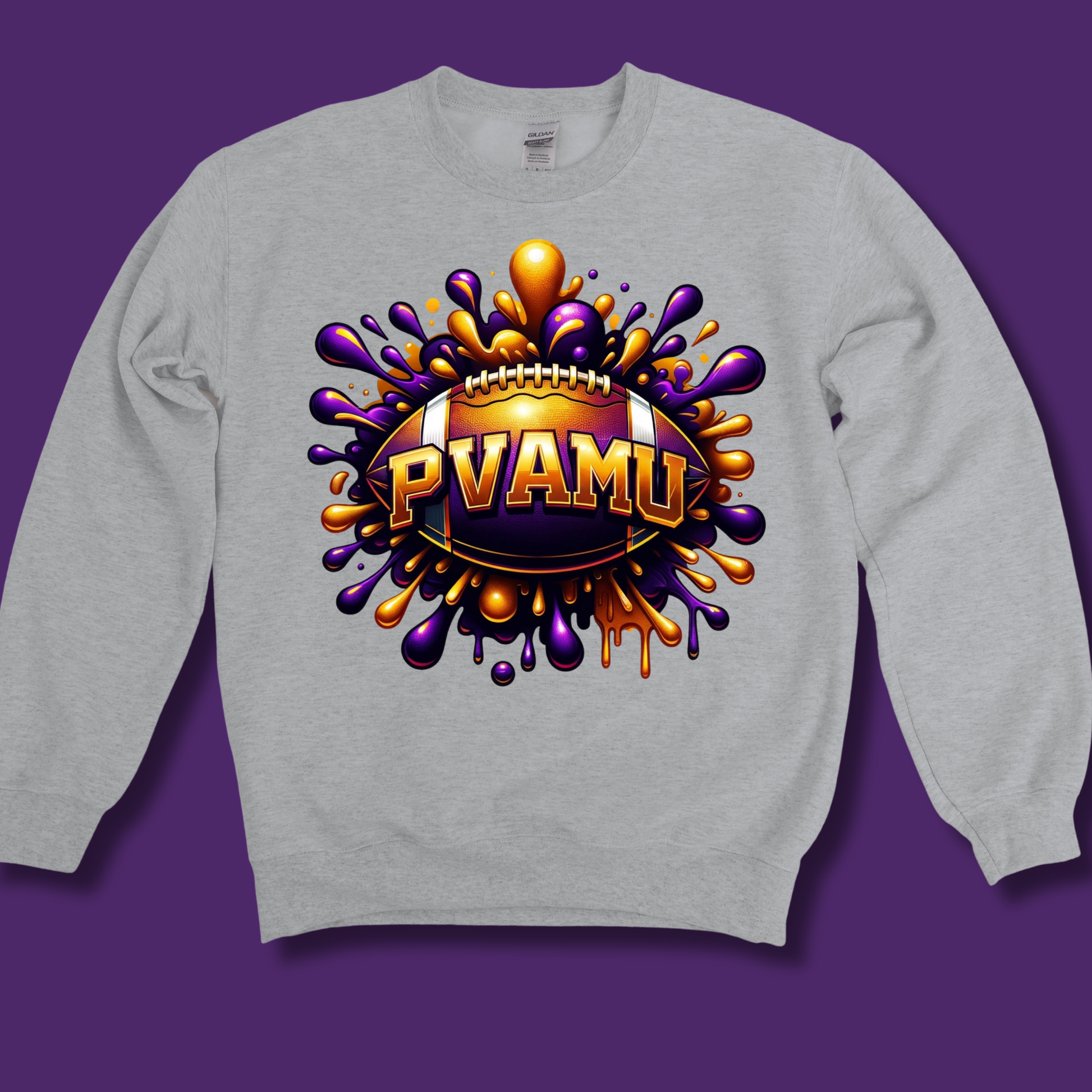 A light gray crewneck sweatshirt featuring a large, vibrant graphic on the chest. The graphic displays a football surrounded by colorful paint splatters in purple, gold, and orange, with the text 'PVAMU' in gold lettering.