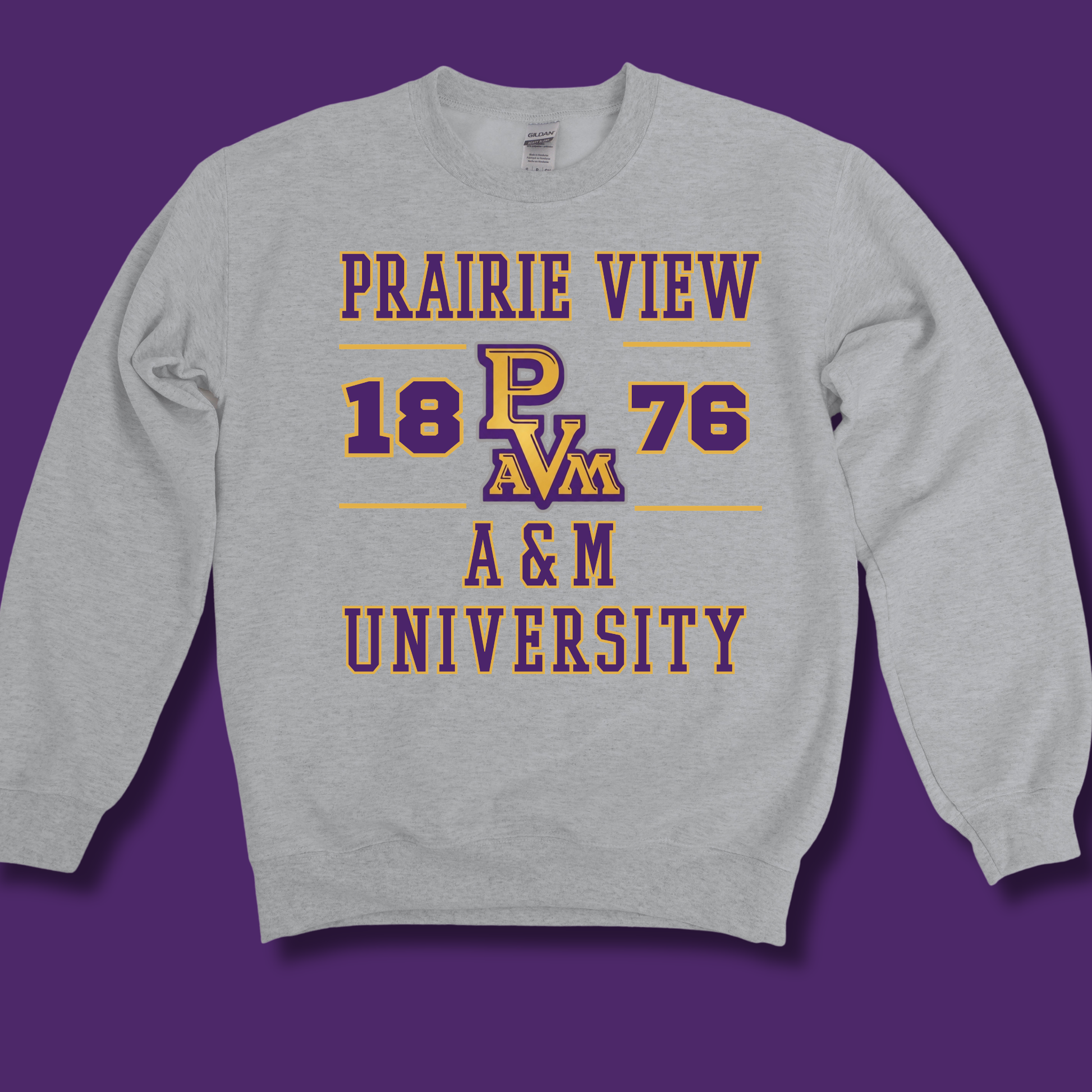 A light heather gray crewneck sweatshirt featuring a purple and gold graphic print that reads 'PRAIRIE VIEW 1876 A&M UNIVERSITY' with 'P A&M' in the center, displayed against a solid purple background.
