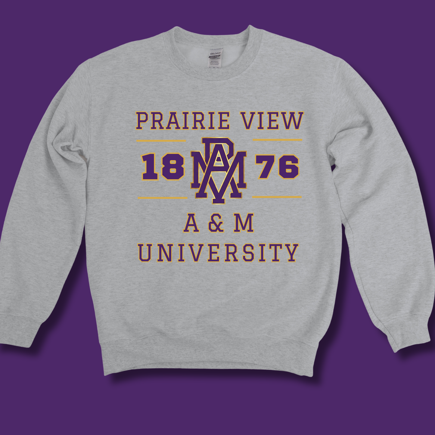 A light heather gray crewneck sweatshirt featuring a purple and maroon graphic print that reads 'PRAIRIE VIEW 1876 A & M UNIVERSITY' with an interlocking 'AM' logo, displayed against a solid purple background.