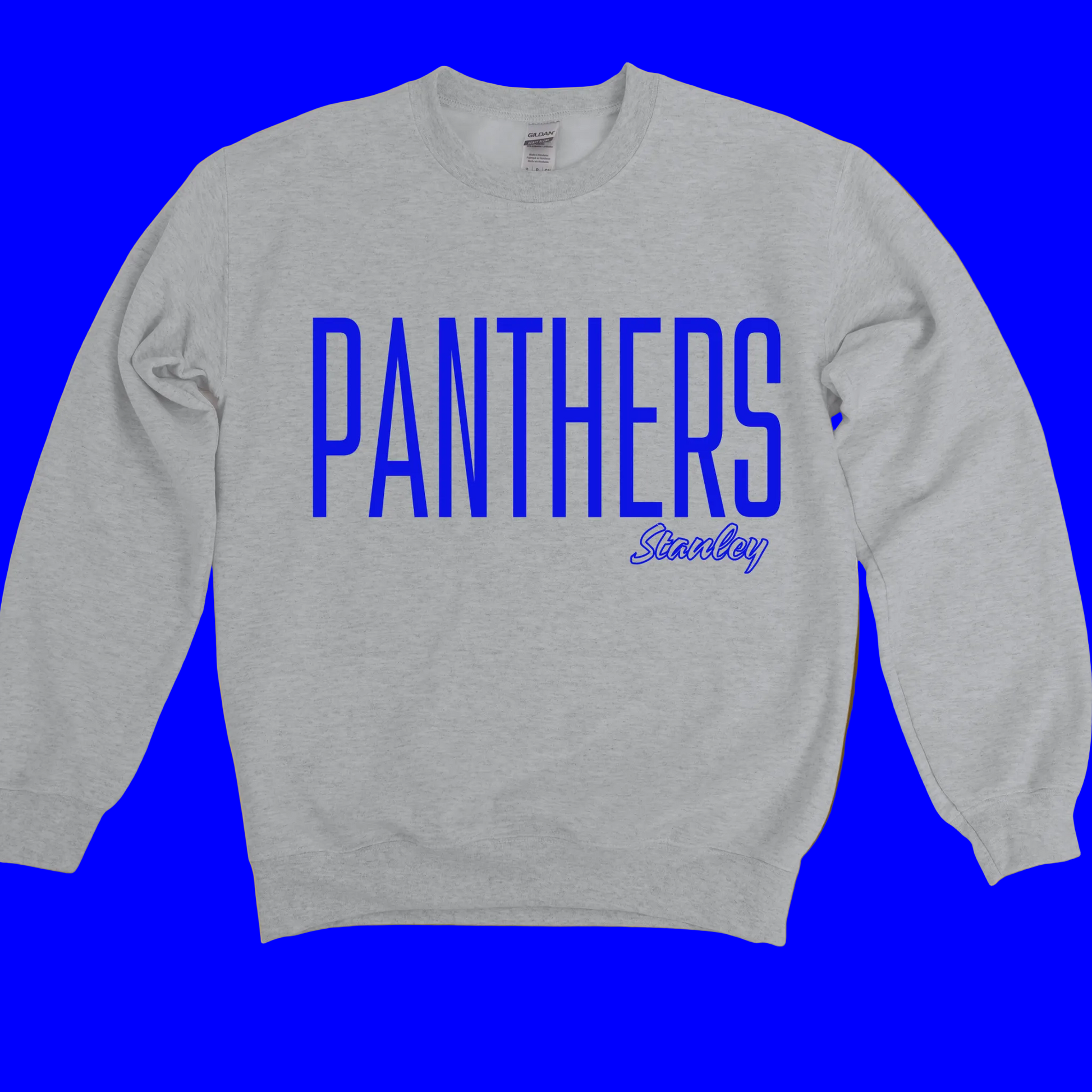 A light heather gray crewneck sweatshirt with a distressed yellow and black graphic on the front that reads 'GRAMBLING' with horizontal stripes above and chevron stripes below, displayed against a solid mustard yellow background.