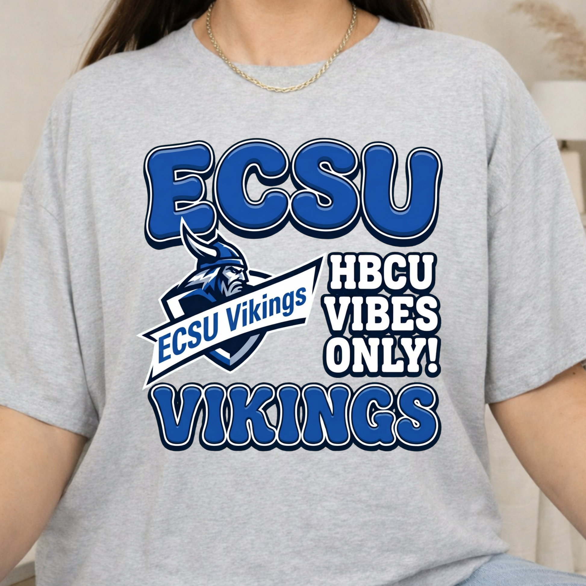 A person wearing a heather gray graphic T-shirt with blue and white text reading 'ECSU', 'ECSU Vikings', 'HBCU VIBES ONLY!', and 'VIKINGS', plus a Viking mascot logo.