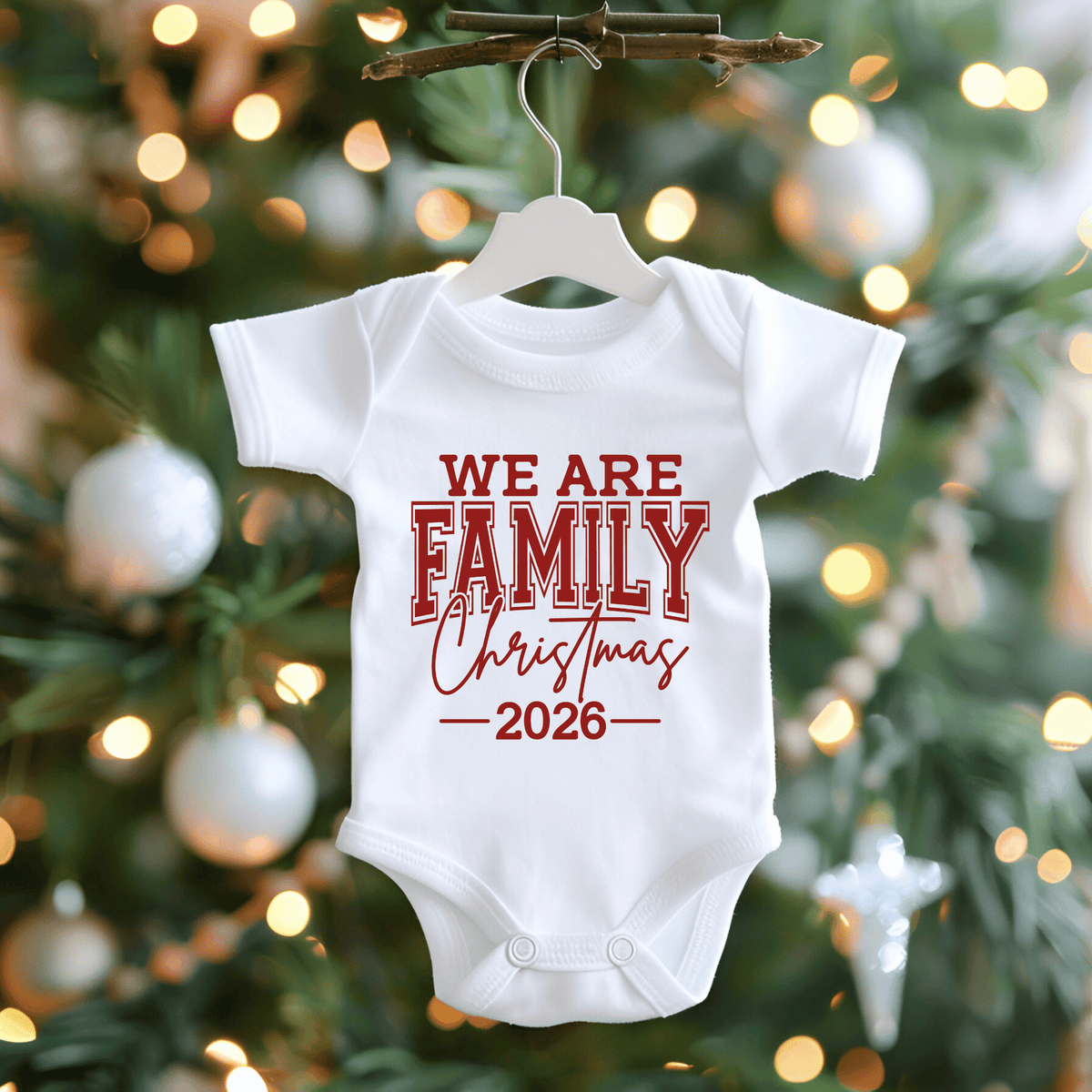 Set of five black matching family t-shirts printed with white 'We Are Family Christmas 2026' collegiate typography on a wooden backdrop.