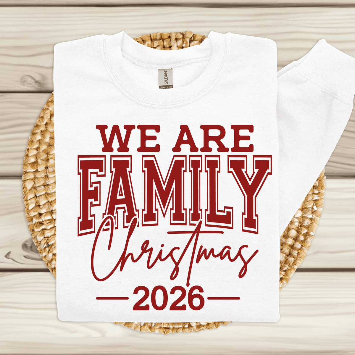 Set of five black matching family t-shirts printed with white 'We Are Family Christmas 2026' collegiate typography on a wooden backdrop.