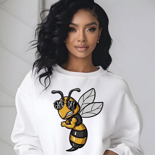 A woman wearing a white crewneck sweatshirt with a cartoon bee graphic on the front. The bee is yellow and black with the text 'GIVE ME DAY' on its sunglasses.