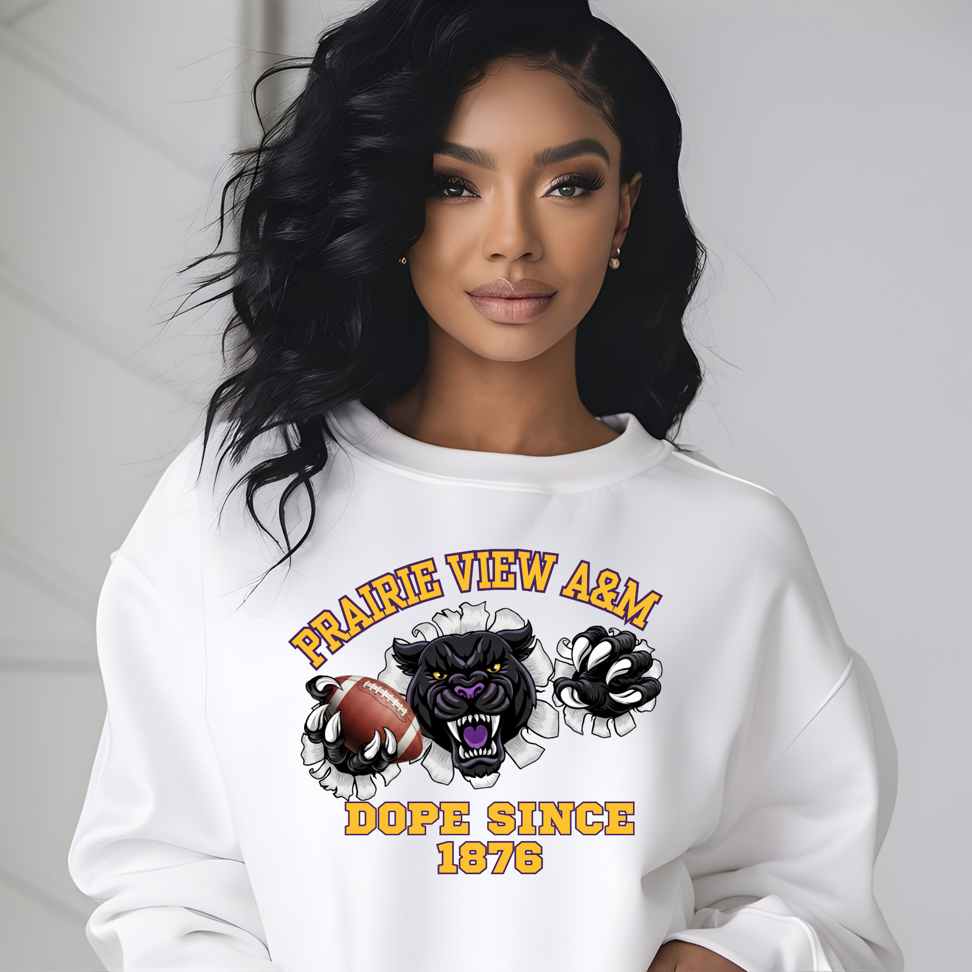 A woman wearing a white crewneck sweatshirt with a graphic print that reads 'PRAIRIE VIEW A&M DOPE SINCE 1876' around an illustration of a panther, football, and gloves.