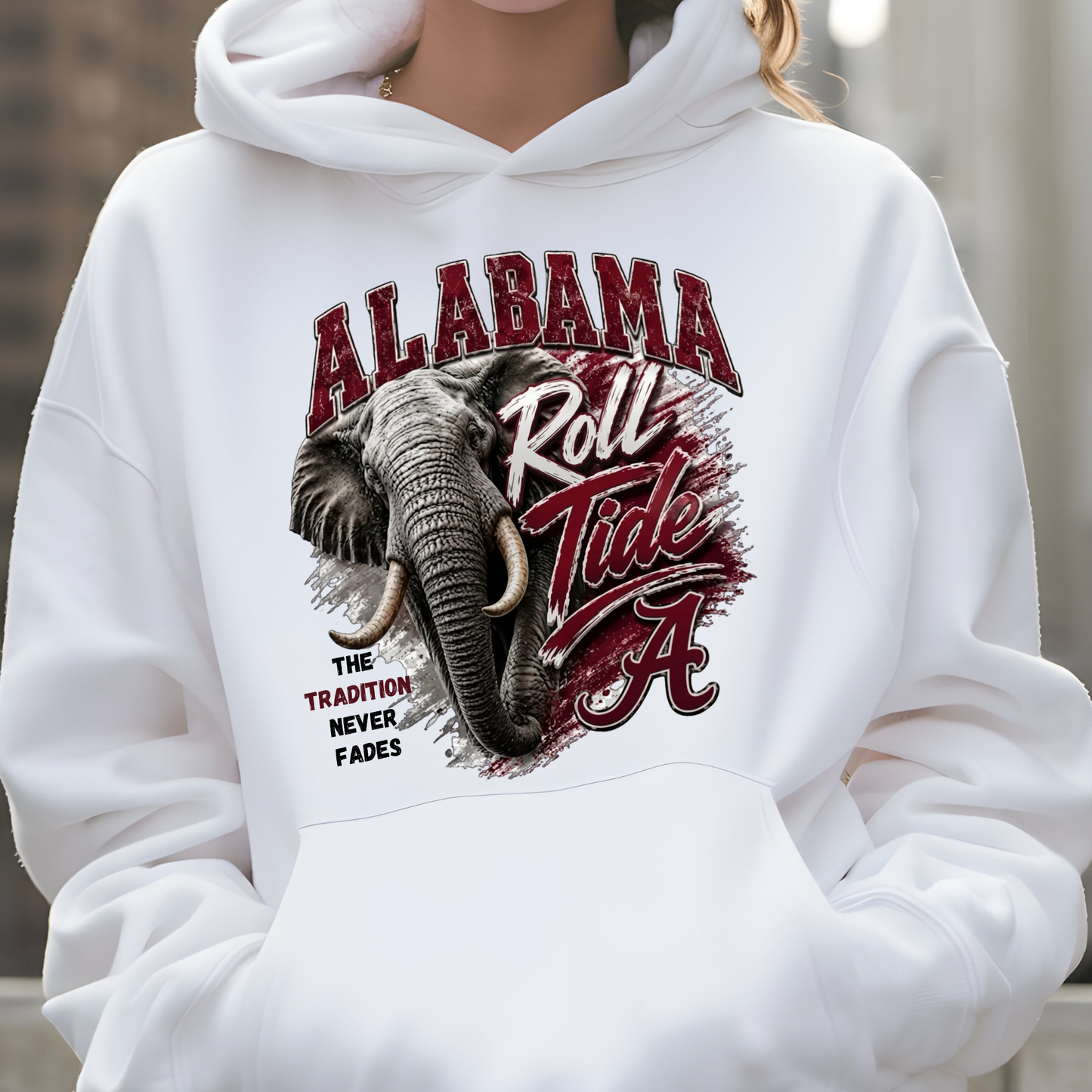A person wearing a white pullover hoodie with a large Alabama Crimson Tide graphic on the front, featuring an elephant illustration and the text 'ALABAMA Roll Tide'.
