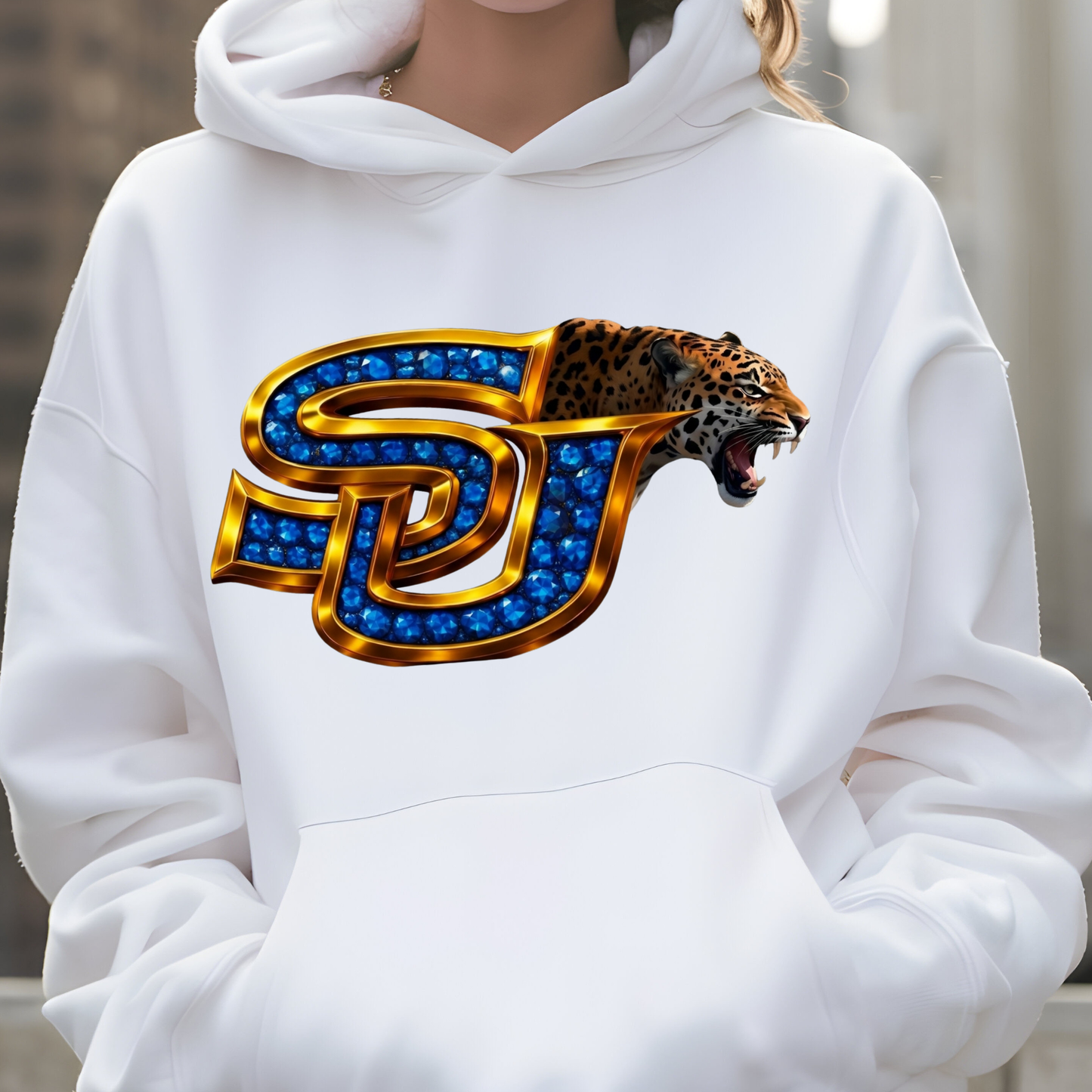A person wearing a white pullover hoodie with a large front graphic featuring interlocking blue and gold letters and a roaring leopard head.