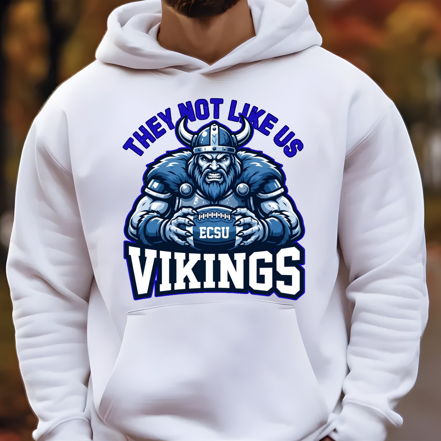A white pullover hoodie worn by a person, featuring a large graphic print of a blue and white Viking football player with the text 'THEY NOT LIKE US VIKINGS' and 'ECSU' on the chest.