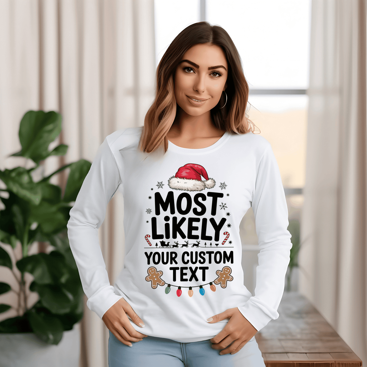 A woman wearing a white long-sleeve t-shirt with a custom Christmas graphic that reads 'MOST LIKELY YOUR CUSTOM TEXT' with a Santa hat, candy canes, and gingerbread cookies, posed in a bright indoor setting.