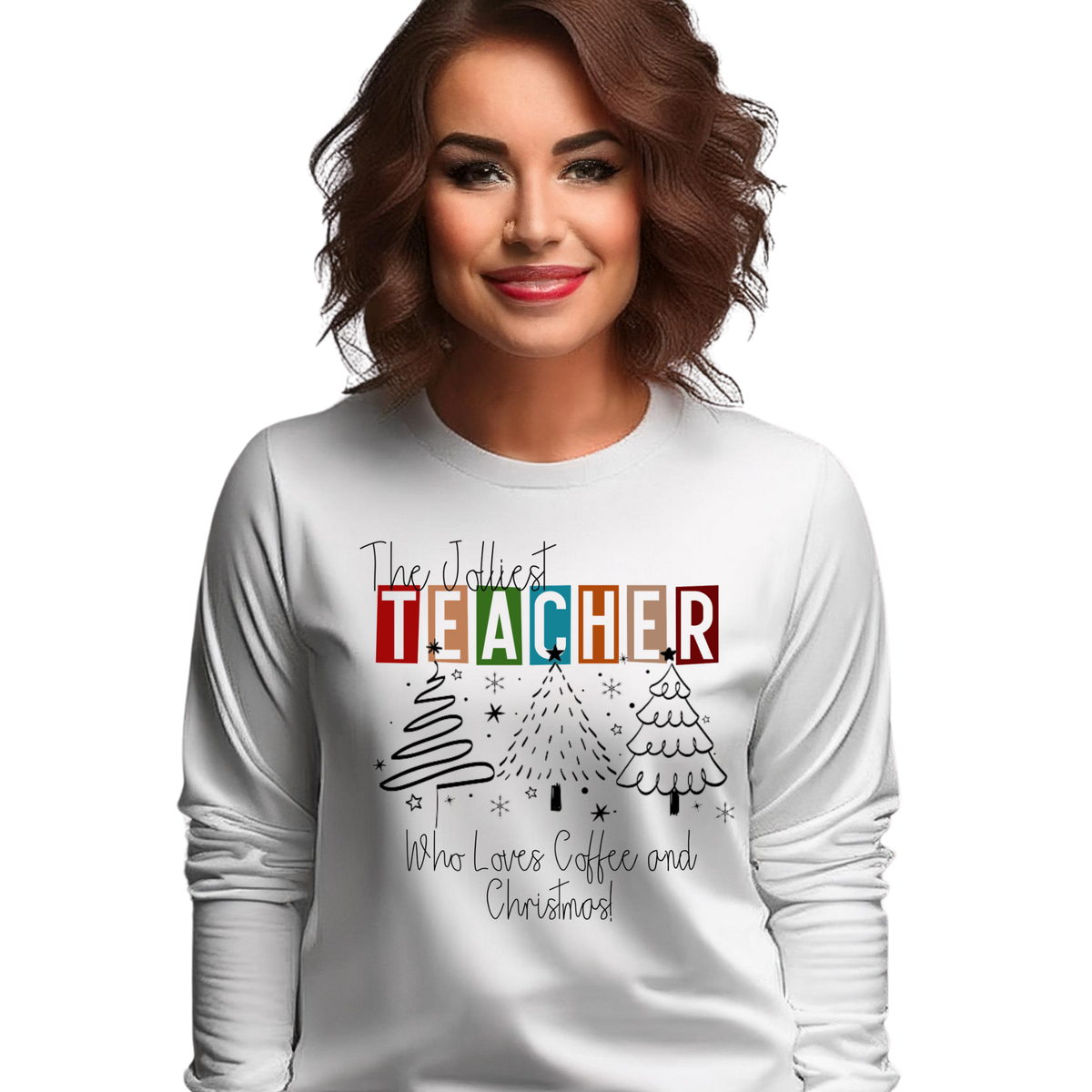 A woman wearing a white long-sleeve crewneck sweatshirt with a colorful graphic that reads 'The Jollyest TEACHER Who Loves Coffee and Christmas' with Christmas tree illustrations, set against a plain white background.