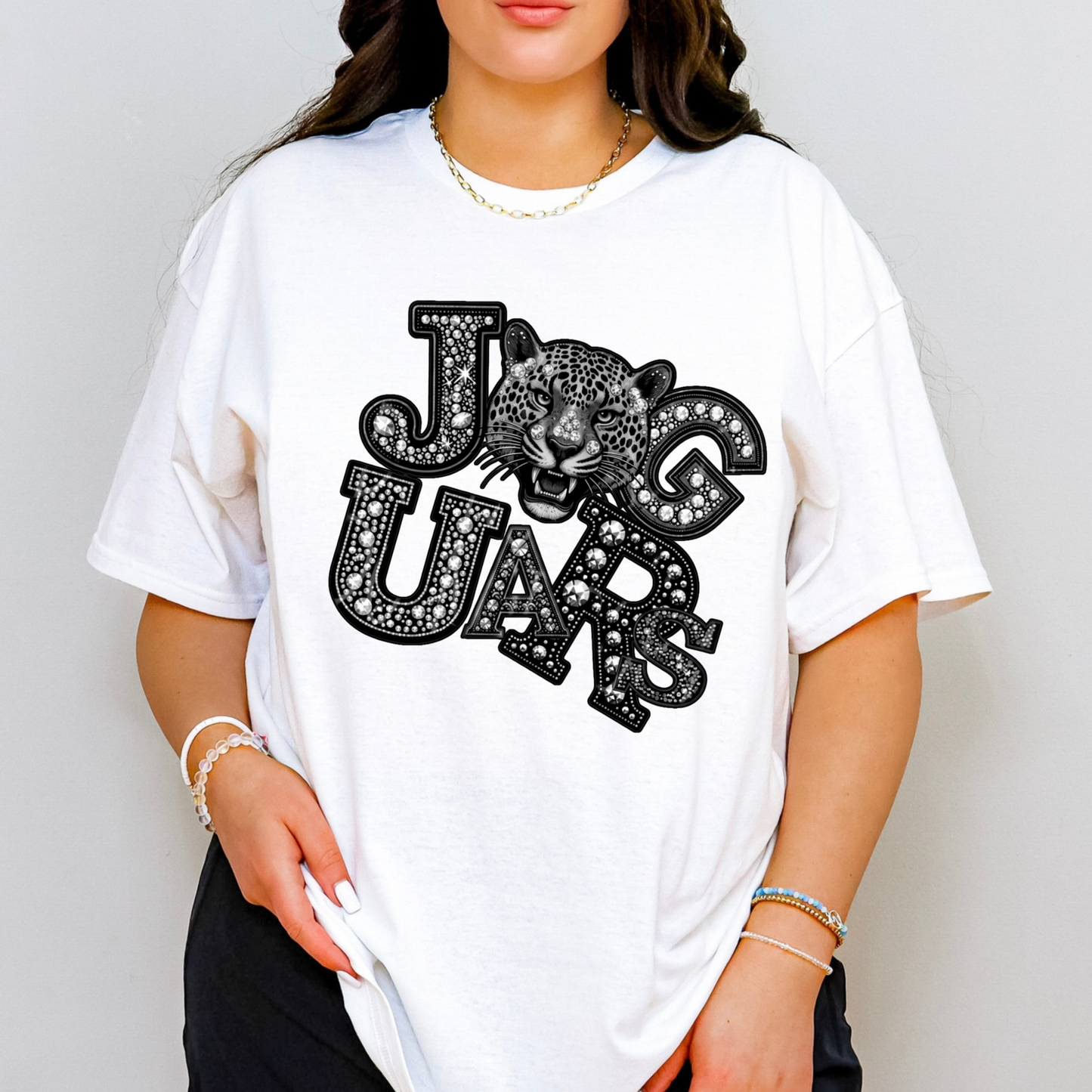 A woman wearing a white oversized graphic t-shirt with a black and white leopard print and the words 'JAG UARS'.