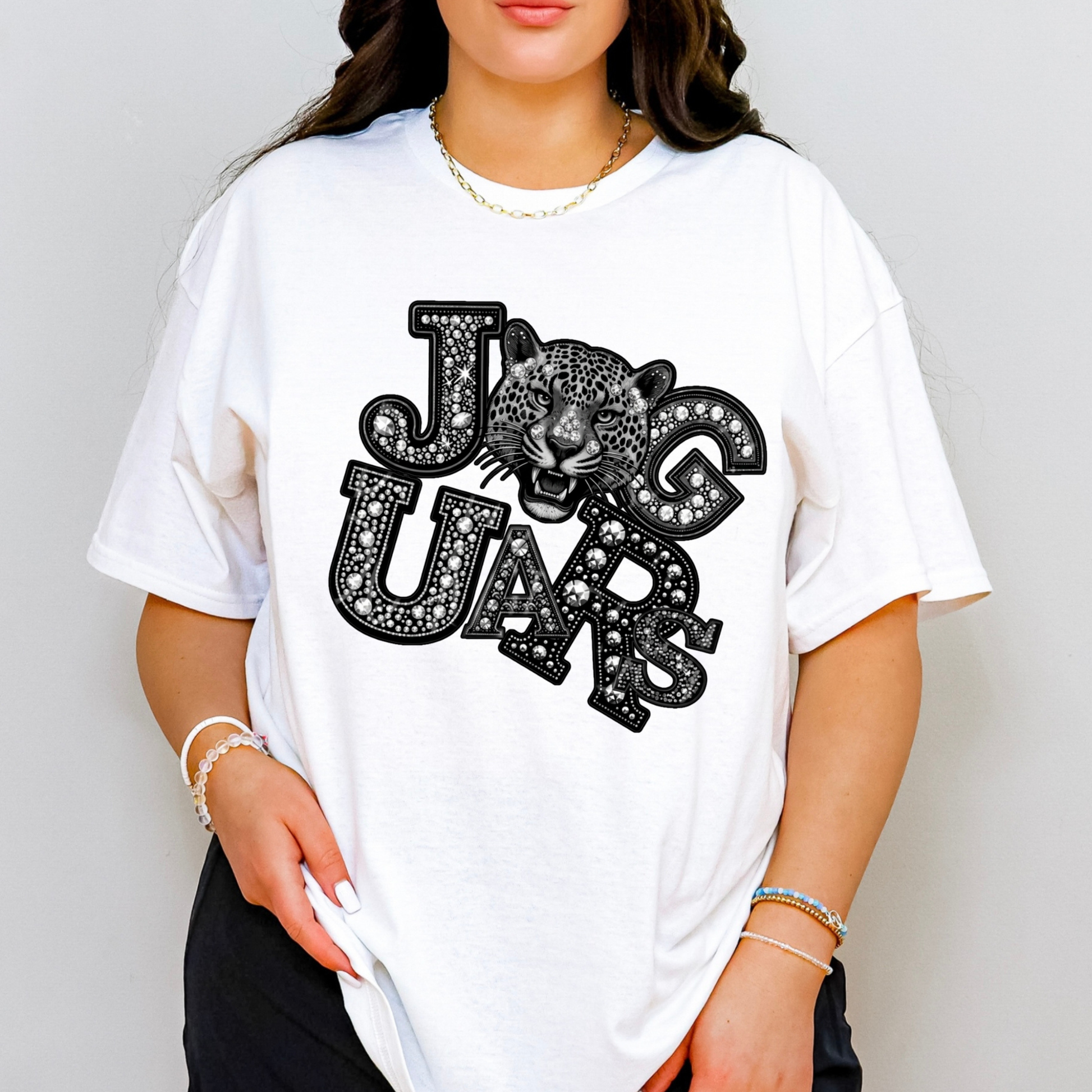 A woman wearing a white oversized graphic t-shirt with a black and white leopard print and the words 'JAG UARS'.
