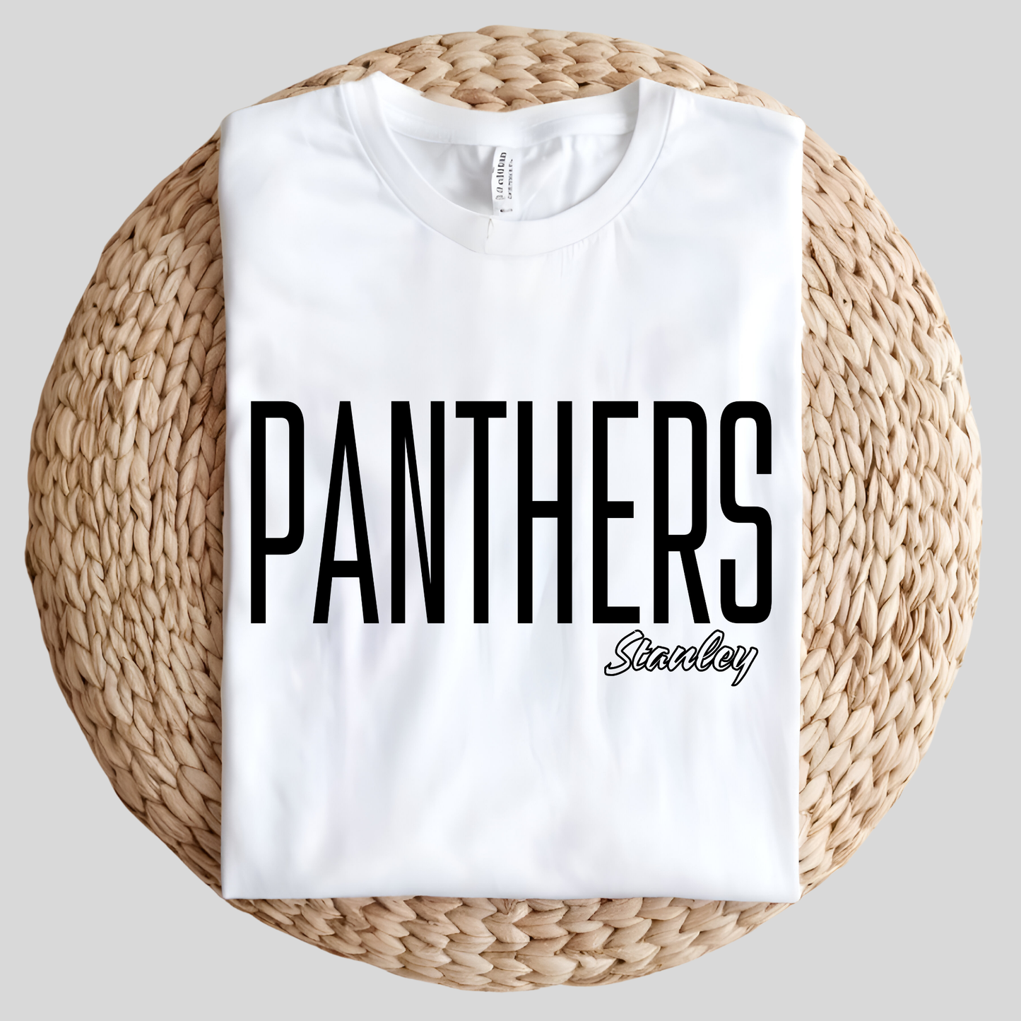 A white short-sleeve t-shirt with a distressed graphic on the front featuring the word 'PANTHERS' in black block letters outlined in red, flanked by red and black stripes, displayed against a solid dark red background.