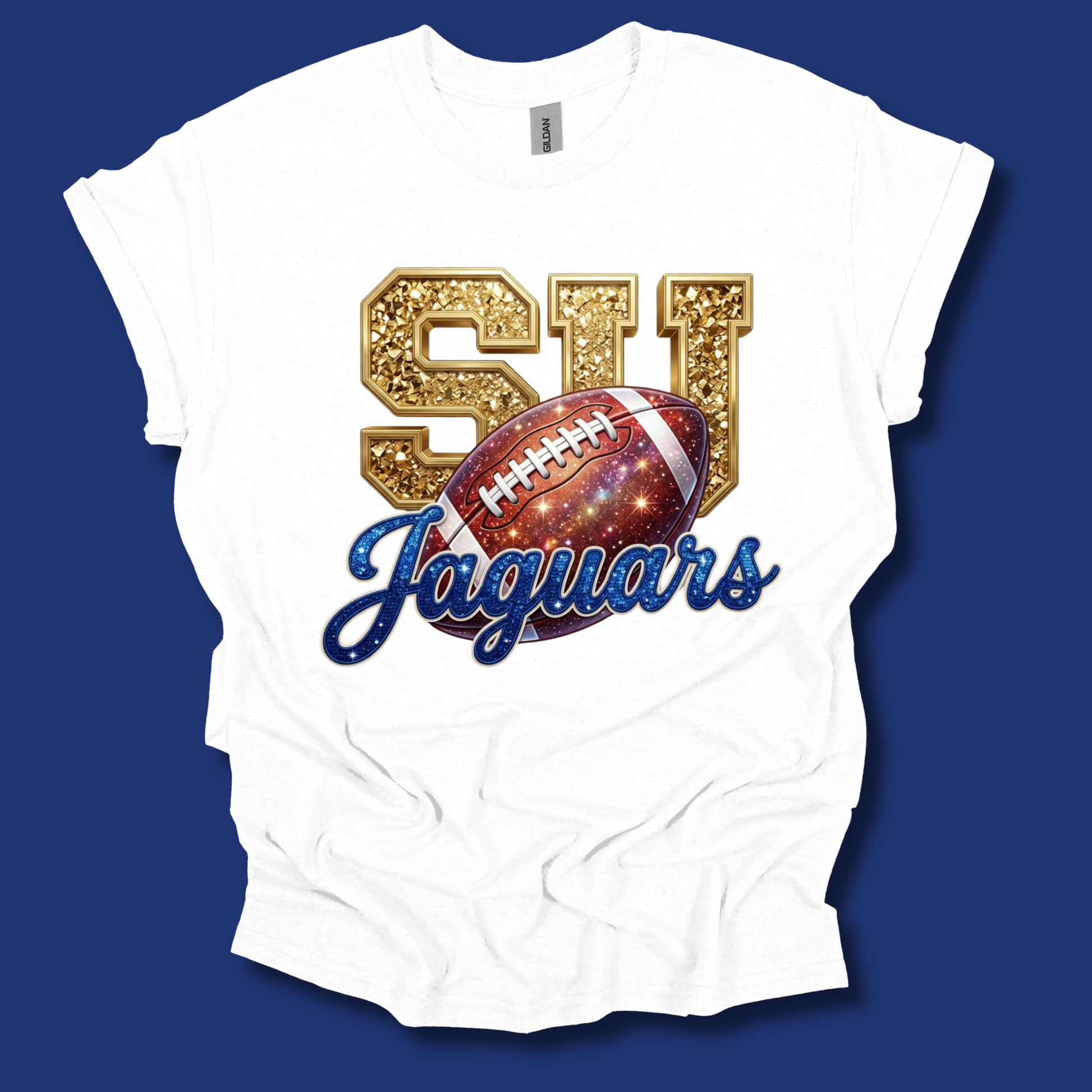 A white short-sleeve t-shirt with a 'SI Jaguars' graphic print. The graphic features glittery gold 'SI' letters, a red and blue galaxy-patterned football, and blue cursive 'Jaguars' text.