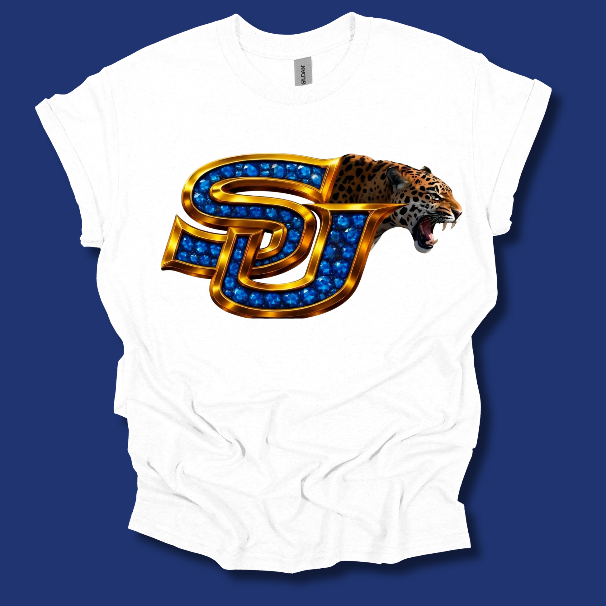A white short-sleeve t-shirt with a large graphic of the 'SD' Utah State University logo, embellished with blue gem-like details and a roaring leopard head, displayed against a solid dark blue background.