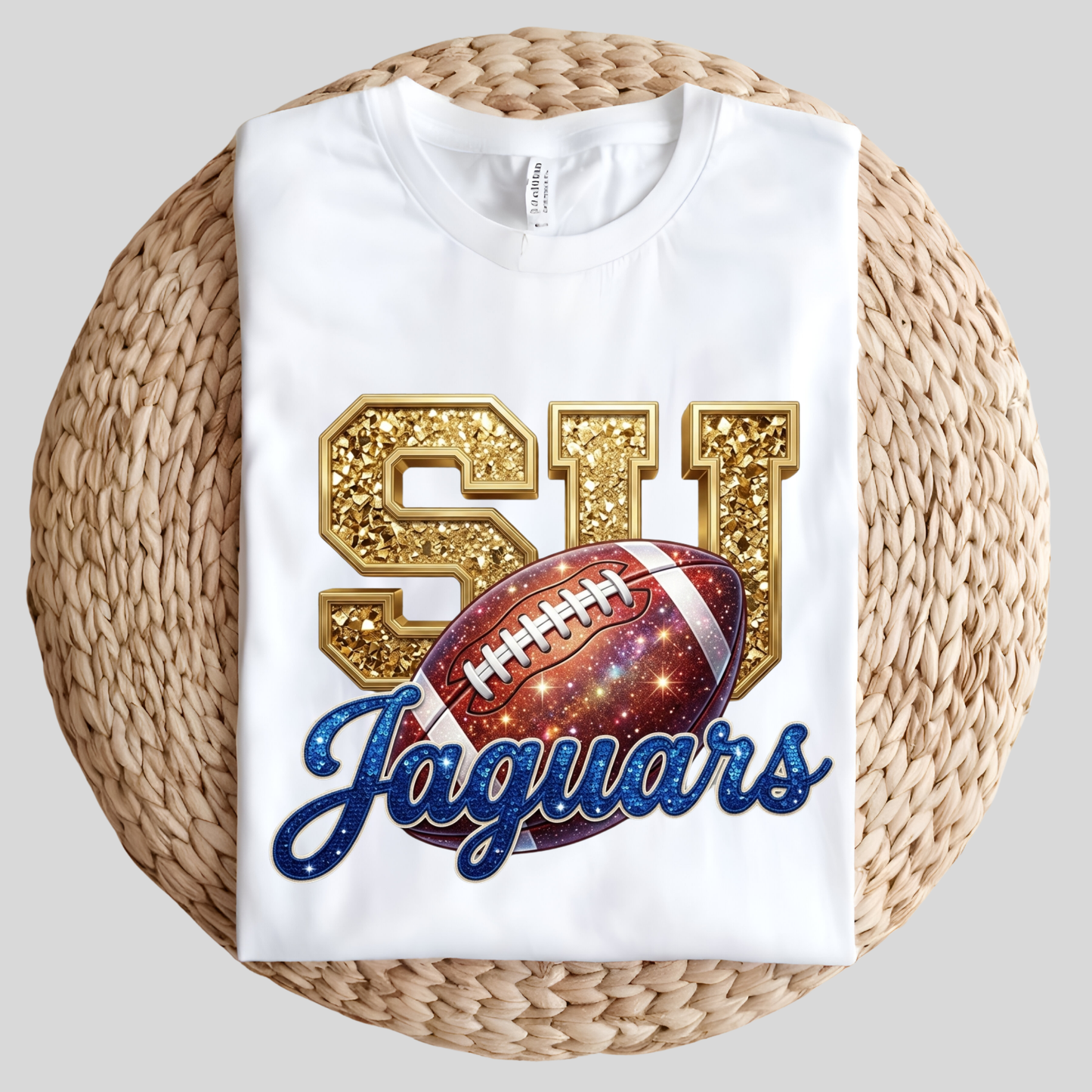 A white short-sleeve t-shirt with a green and black 'GATORS' collegiate graphic, laid flat on a round woven straw mat against a light gray background.