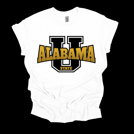A white short-sleeve t-shirt with a graphic on the front featuring a large black and white 'U' outline, the word 'ALABAMA' in bold gold letters, and 'STATE' in gold below it, displayed against a solid black background.