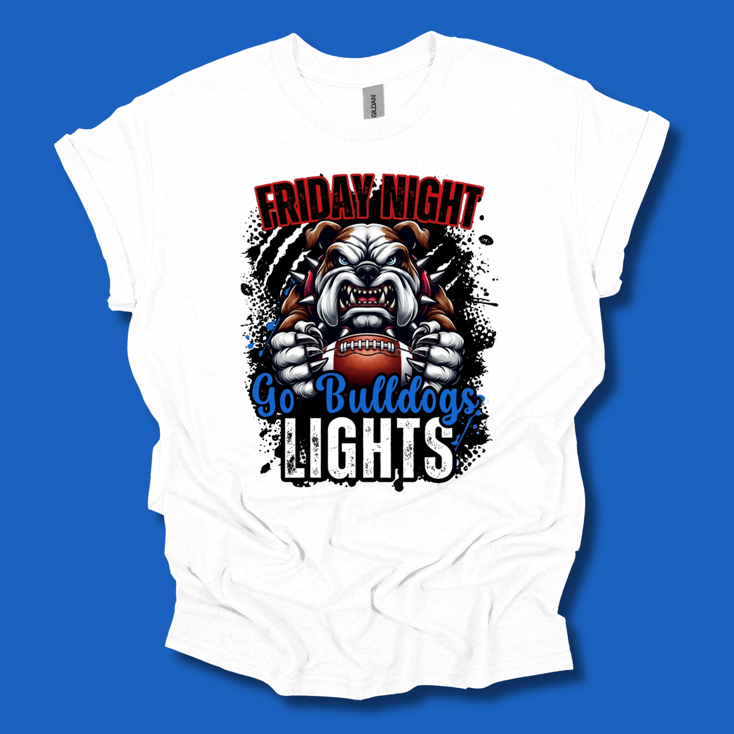 A white short-sleeve t-shirt with a graphic print of a bulldog mascot holding a football, with the text 'FRIDAY NIGHT' in red and 'Go Bulldogs LIGHTS' in blue and white, displayed against a solid blue background.
