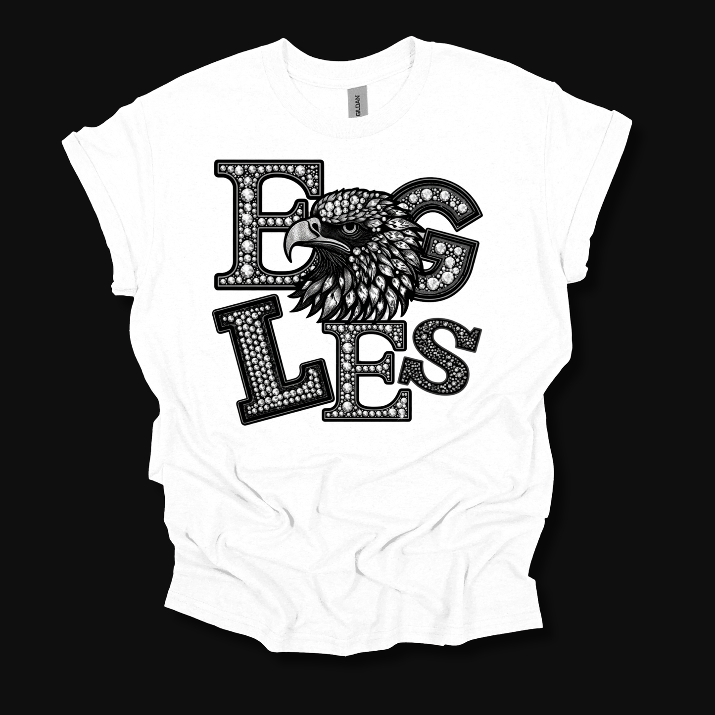 A white short-sleeve t-shirt with a black graphic print featuring the word 'EGLES' in a dotted, textured font and an eagle's head integrated into the design, displayed on a solid black background.