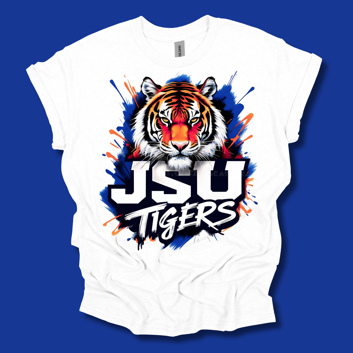 A white short-sleeve t-shirt with a vibrant graphic of a tiger's face and the text 'JSU TIGERS' in white with black outlines, set against a solid blue background.