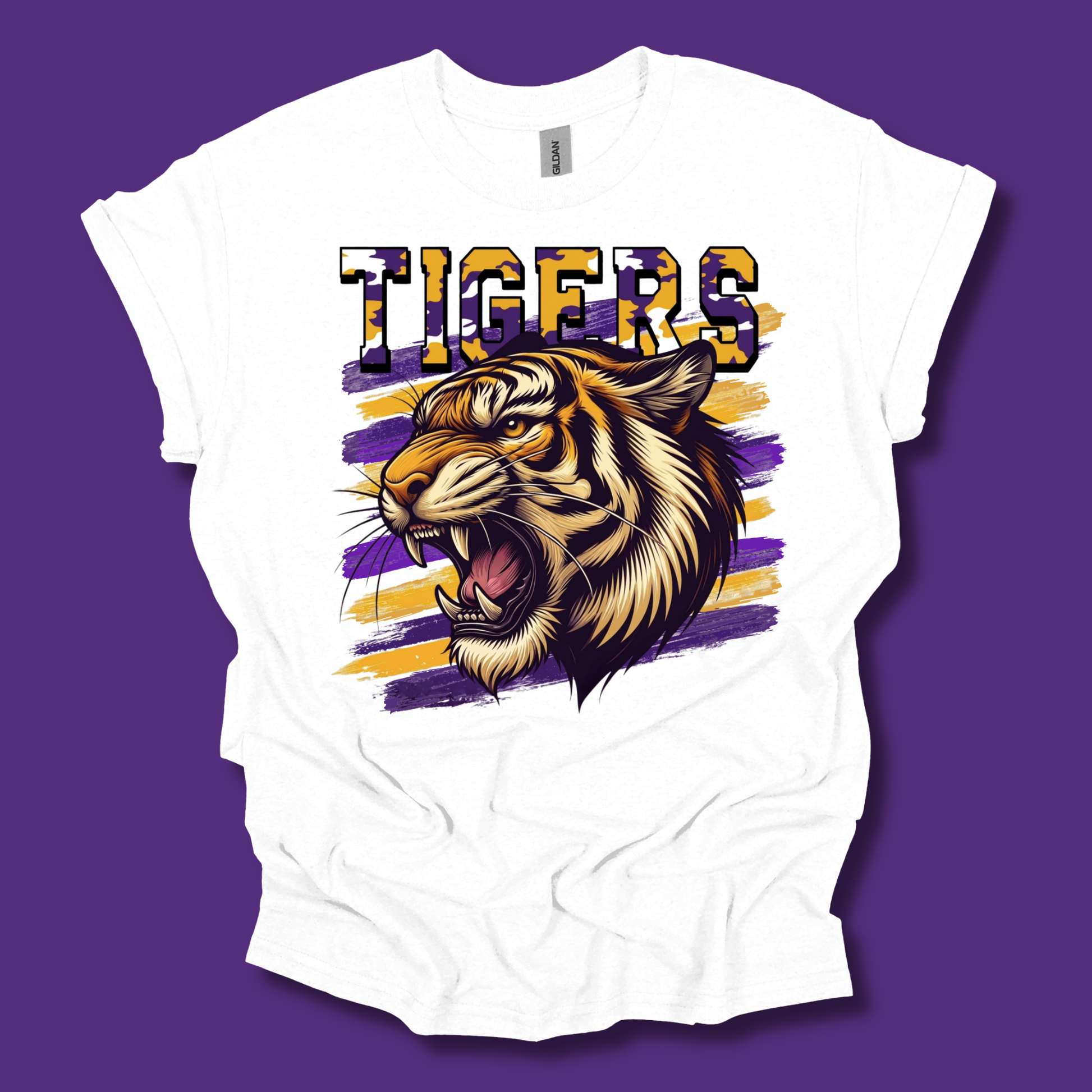 A white short-sleeve t-shirt with a graphic print of a roaring tiger and the word 'TIGERS' in purple and gold, displayed against a solid purple background.