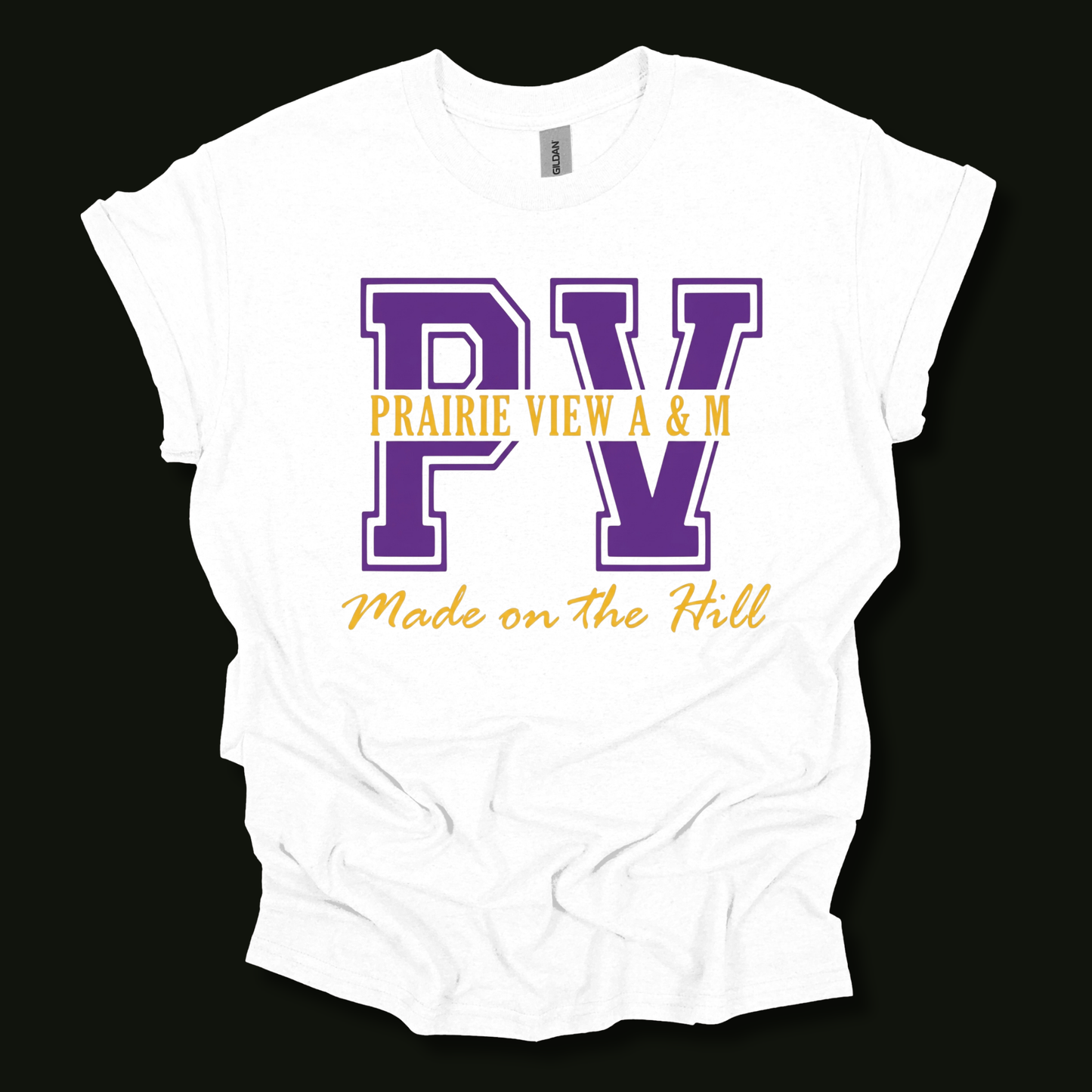 A white short-sleeve t-shirt with a purple and yellow graphic print on the front. The graphic features the letters 'PV' in purple varsity block font, with 'PRAIRIE VIEW A & M' printed in yellow across the middle, and 'Made on the Hill' in yellow script below.
