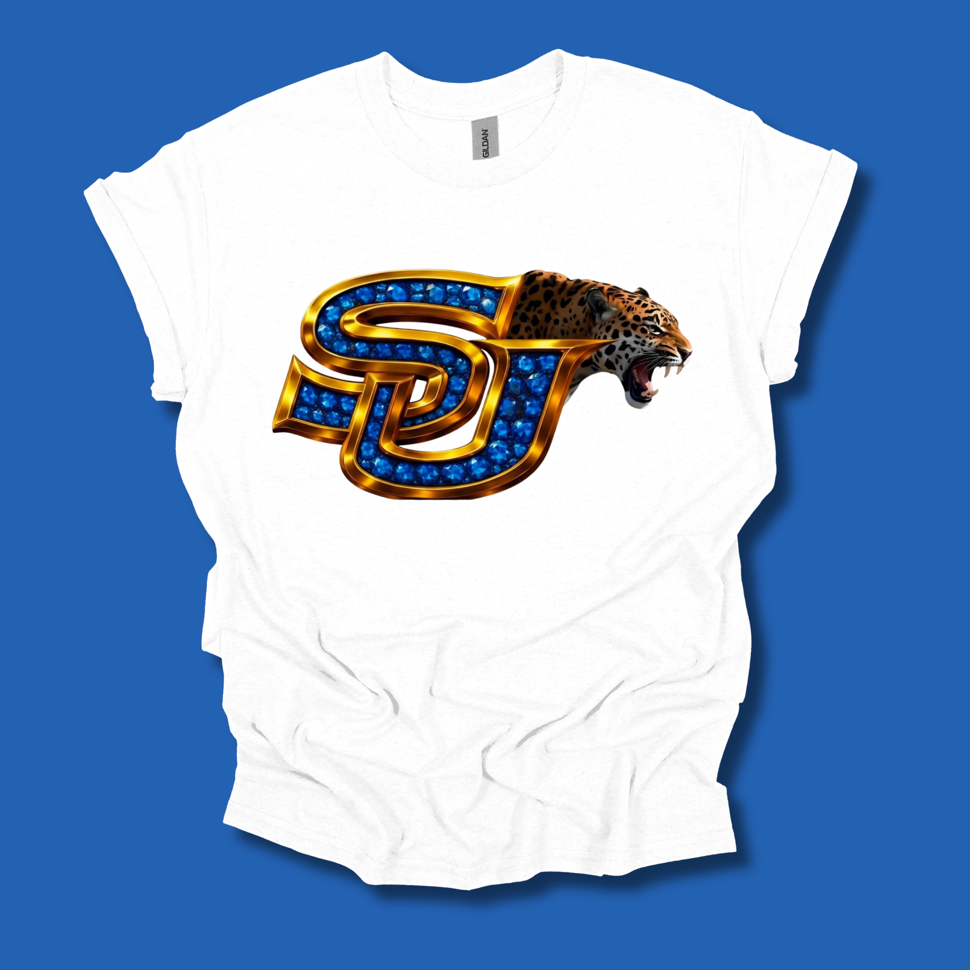 A white short-sleeve t-shirt with a graphic of a stylized 'SJ' monogram outlined in gold and filled with blue gem-like details, with a leopard head emerging from the right side, displayed against a solid blue background.