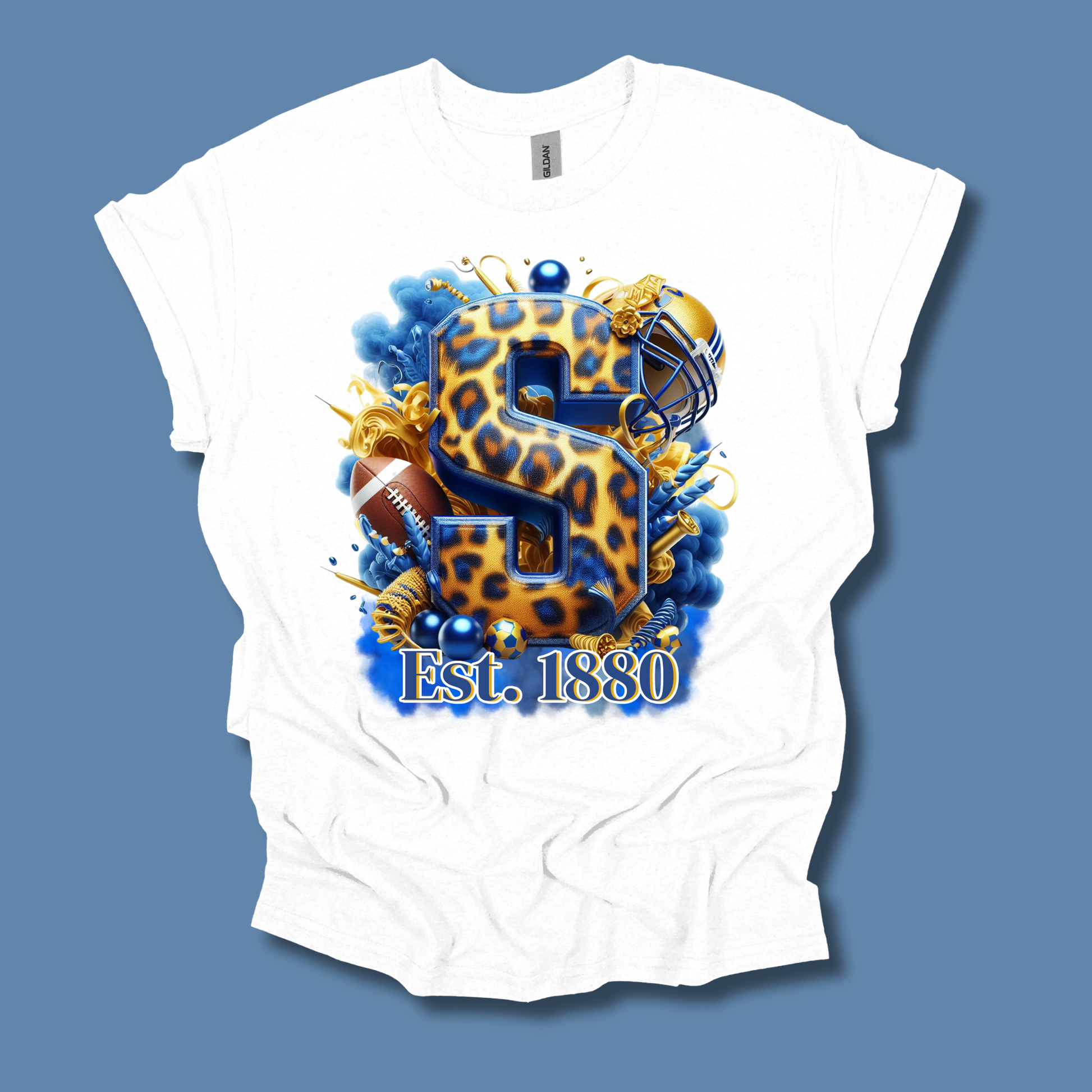 A white short-sleeve t-shirt with a large graphic print on the front. The graphic features a leopard-print letter 'S' in blue and gold, surrounded by football elements, a football helmet, and the text 'Est.